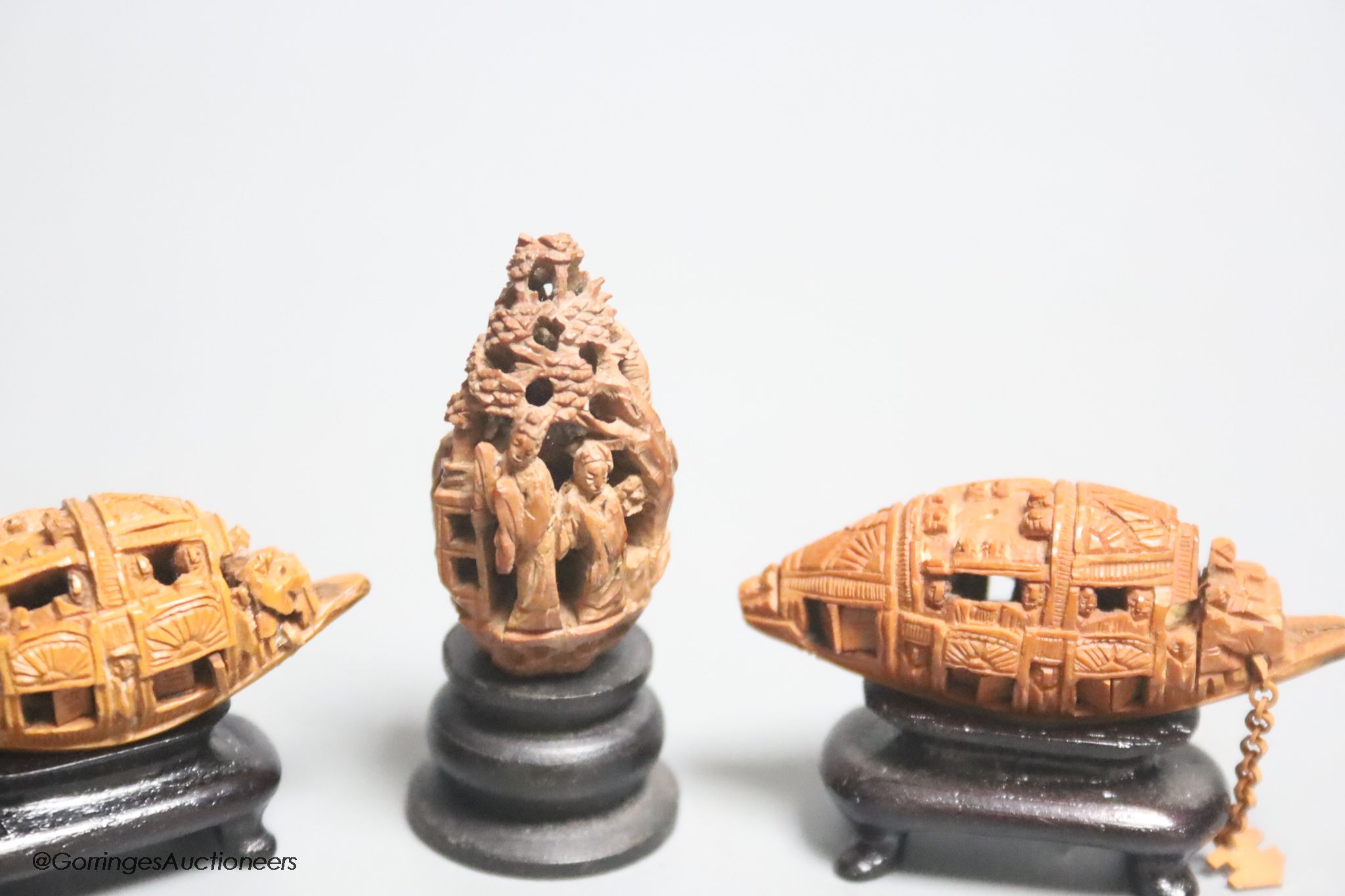 Three Chinese peach stone carvings on stands